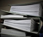 Close-up of stacked binders filled with documents for office or educational use.