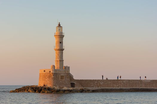 The iconic Chania Lighthouse stands elegantly against a warm evening sky, Greece.